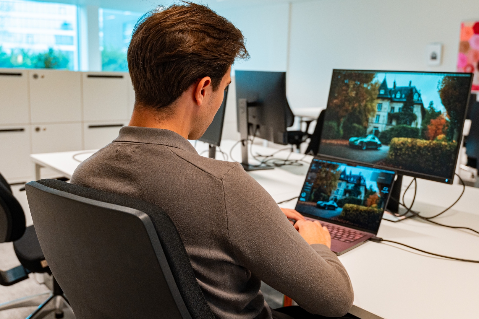 Webdesigner werkt aan het creëren van een website met webdesign op maat op een computer.